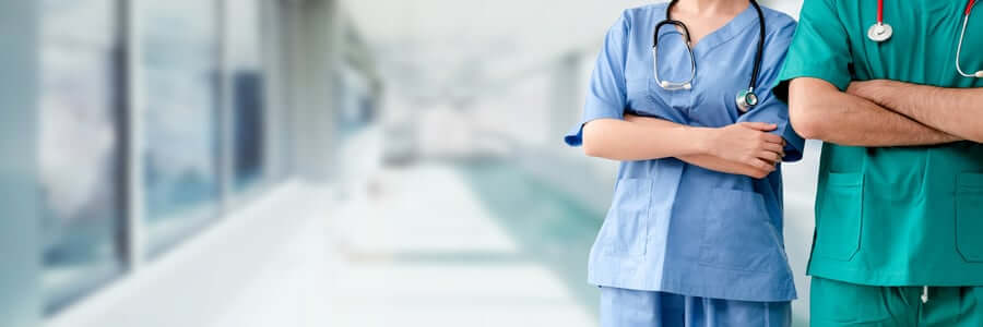 Two hospital staffs - surgeon, doctor or nurse standing with arms crossed in the hospital. Medical healthcare and doctor service.