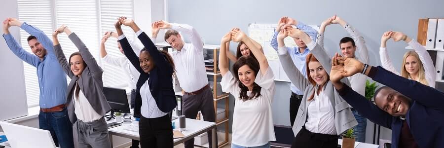 Group Of Smiling Multi-ethnic Businesspeople Doing Stretching Exercise At Workplace