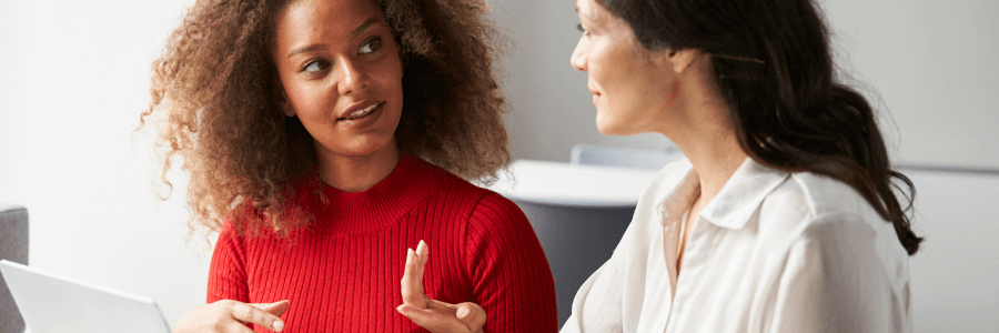 Two employees chatting during a one-on-one meeting.